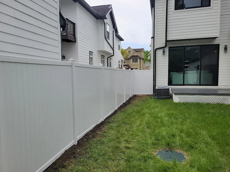 White vinyl privacy fence enclosing a backyard