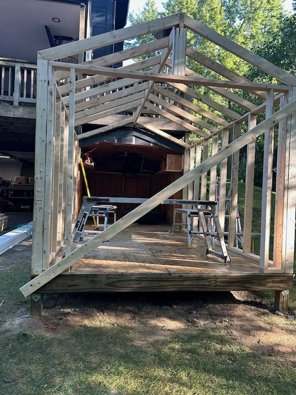New wall and roof framing built around an existing backyard shed