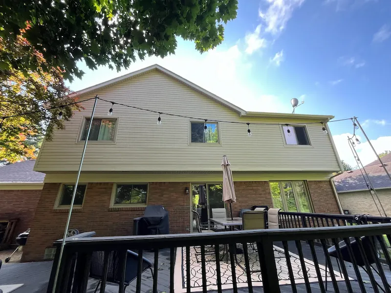 Rear of a two-story home with completed siding and window trim