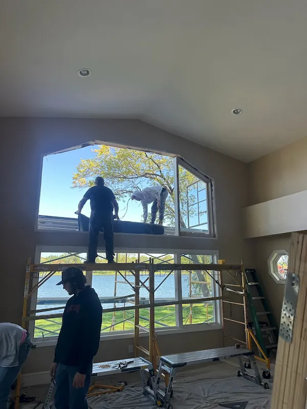 Contractors installing a large arched feature window